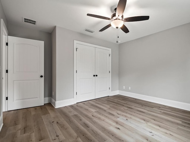 unfurnished bedroom with ceiling fan, light hardwood / wood-style floors, and a closet