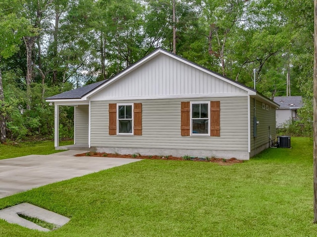 view of side of property featuring a lawn and cooling unit