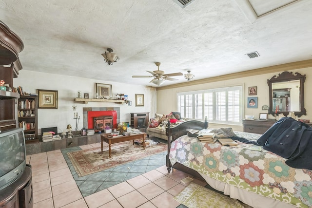 living room featuring a tile fireplace, ceiling fan, a textured ceiling, and light tile patterned floors