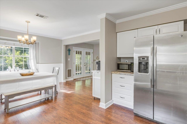 6447 Joe Cotton Trl, Tallahassee, FL 32309 - kitchen with stainless steel refrigerator with ice dispenser, a chandelier, healthy amount of natural light, white cabinetry, and ornamental molding