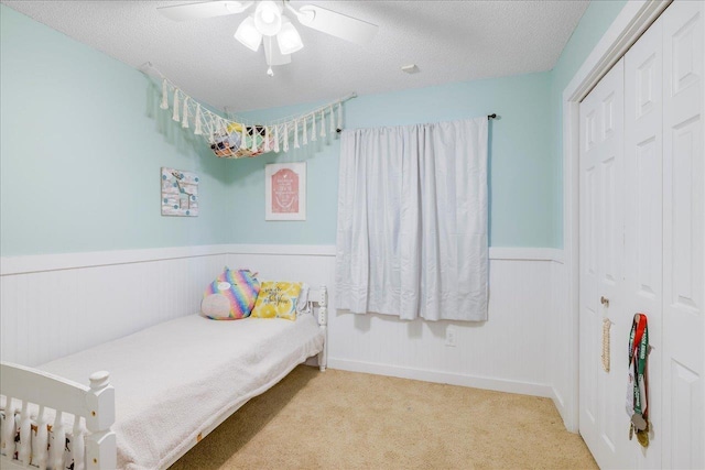 6447 Joe Cotton Trl, Tallahassee, FL 32309 - carpeted bedroom featuring a wainscoted wall, a textured ceiling, a closet, and ceiling fan