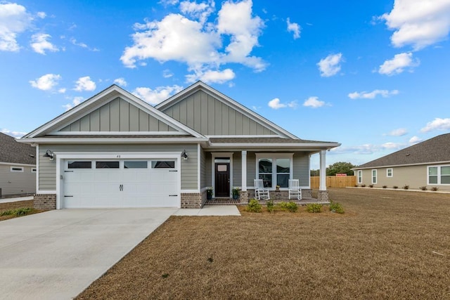 craftsman-style home featuring a porch, a garage, and a front yard