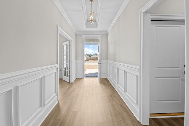 hall with crown molding and light hardwood / wood-style floors