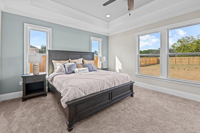 bedroom with ornamental molding, carpet floors, ceiling fan, and a tray ceiling