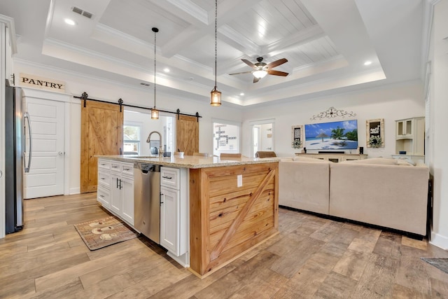 kitchen featuring crown molding, a barn door, a sink, and stainless steel appliances