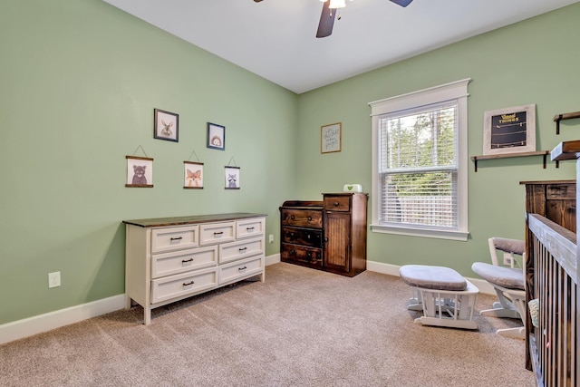 living area with ceiling fan, light carpet, and baseboards