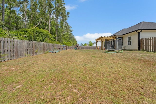 view of yard with a fenced backyard, a trampoline, and a pergola