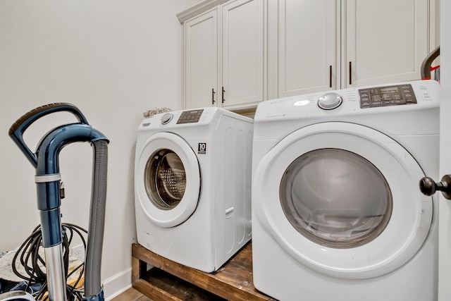 washroom with washing machine and dryer, dark wood-style floors, and cabinet space