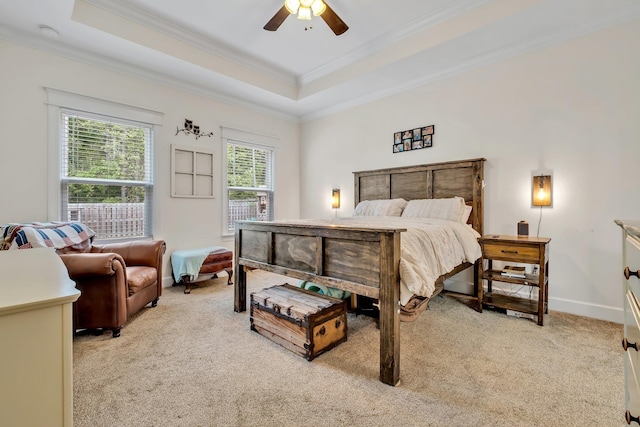 bedroom with crown molding, baseboards, a tray ceiling, and light colored carpet