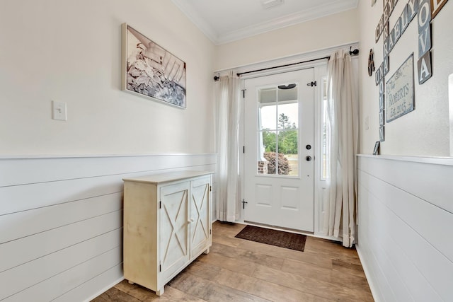 doorway to outside with crown molding and light wood-style floors
