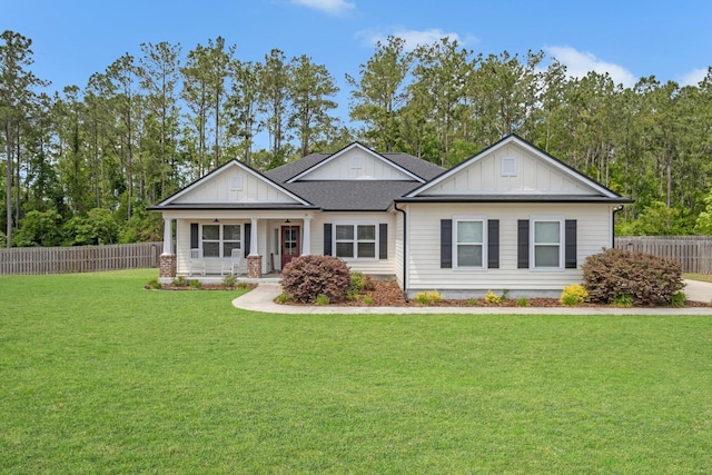craftsman house featuring fence, covered porch, board and batten siding, and a front yard