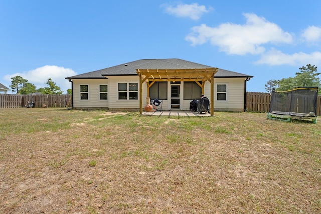 rear view of house with a pergola, a trampoline, a fenced backyard, a lawn, and a patio