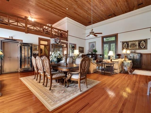 dining space featuring hardwood / wood-style floors, a high ceiling, ceiling fan, and wood ceiling