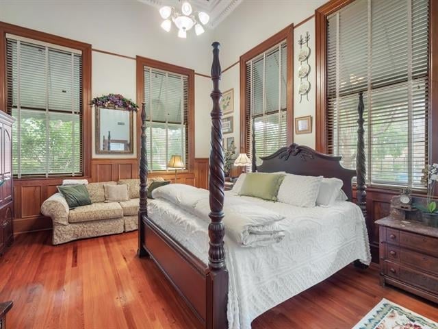 bedroom with hardwood / wood-style floors and wood walls