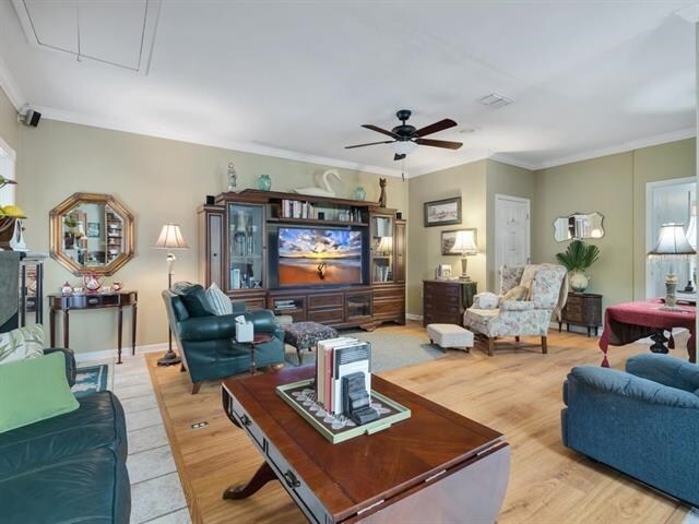 living room featuring light hardwood / wood-style floors, ceiling fan, and crown molding