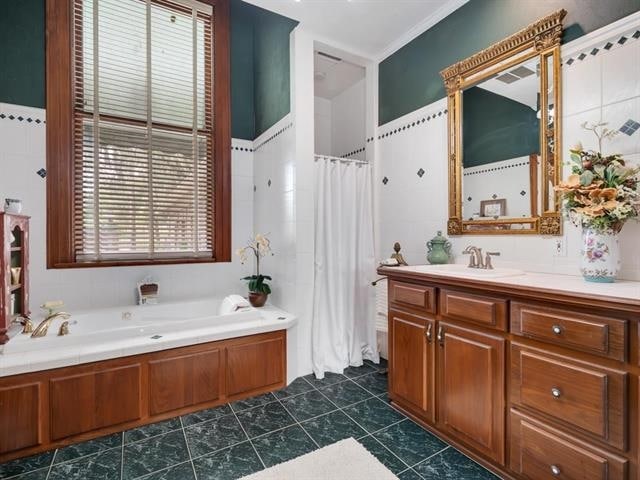 bathroom featuring ornamental molding, vanity, a tub to relax in, and tile patterned floors