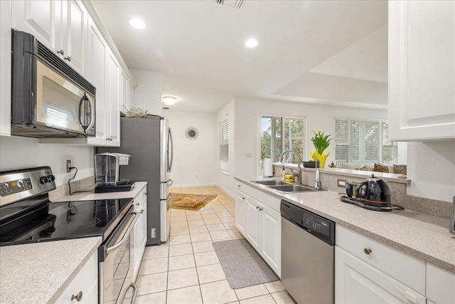 kitchen featuring white cabinets, light tile patterned floors, sink, and appliances with stainless steel finishes