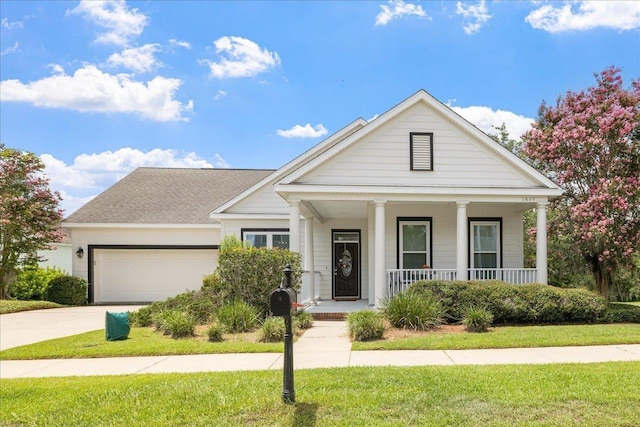 view of front of property with a front yard, a porch, and a garage