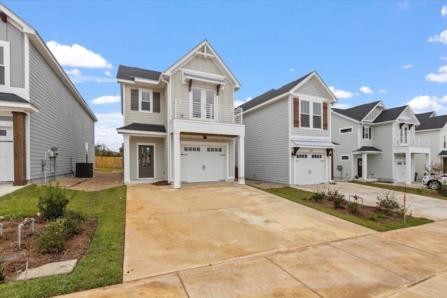 view of front facade featuring a balcony, concrete driveway, a garage, central air condition unit, and board and batten siding