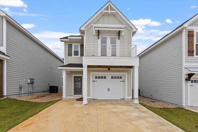 view of front facade featuring board and batten siding, concrete driveway, a garage, a balcony, and central AC unit