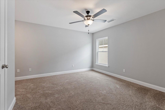 carpeted spare room with visible vents, ceiling fan, and baseboards