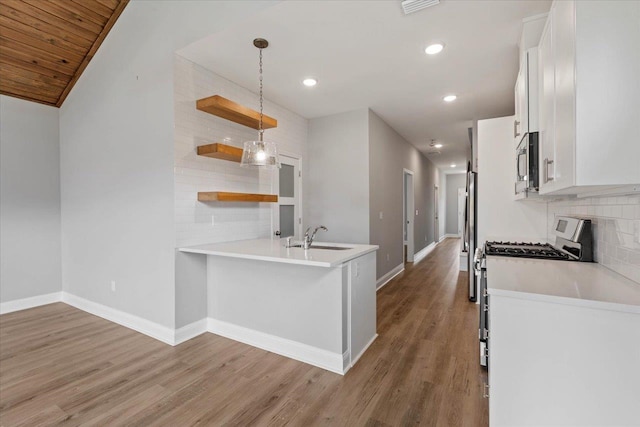 kitchen featuring backsplash, light wood-type flooring, stainless steel appliances, white cabinetry, and open shelves