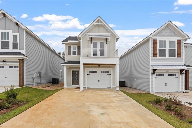 view of front of house with a garage, cooling unit, board and batten siding, and a balcony