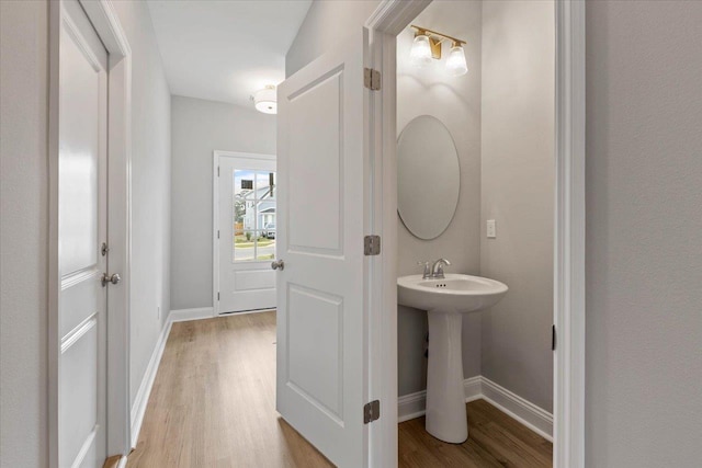 bathroom featuring a sink, baseboards, and wood finished floors