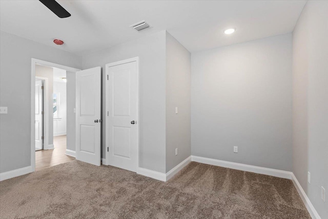 unfurnished bedroom with visible vents, recessed lighting, baseboards, and carpet