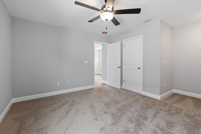 unfurnished bedroom featuring visible vents, baseboards, carpet, and a ceiling fan