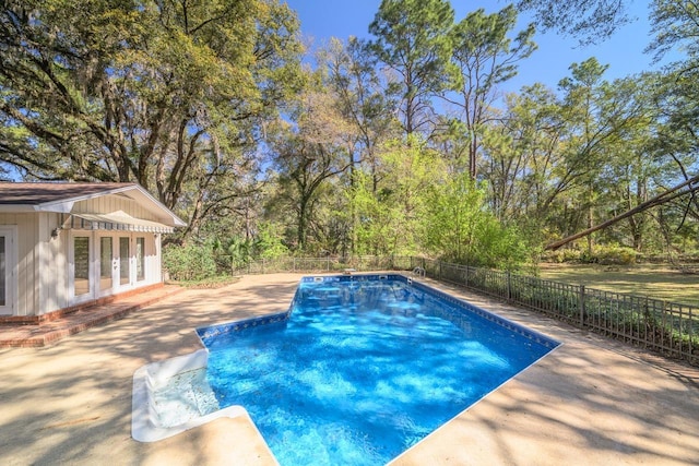 view of swimming pool featuring a patio, a fenced backyard, a diving board, french doors, and a fenced in pool