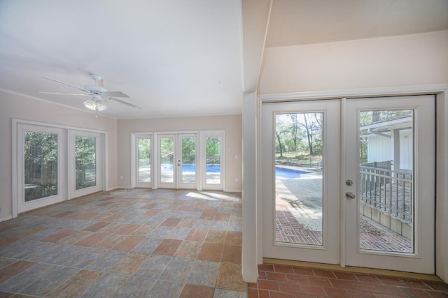 unfurnished sunroom with a ceiling fan and french doors