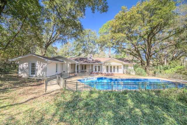 view of swimming pool with a patio, french doors, fence, and a fenced in pool