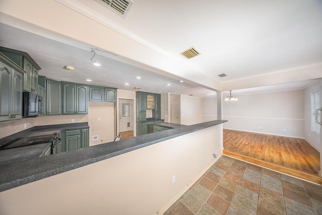 kitchen featuring dark countertops, black microwave, visible vents, and stone finish flooring