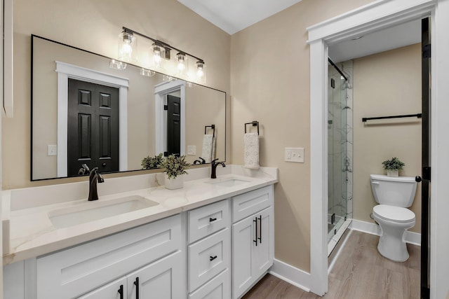 full bathroom featuring double vanity, a stall shower, and a sink