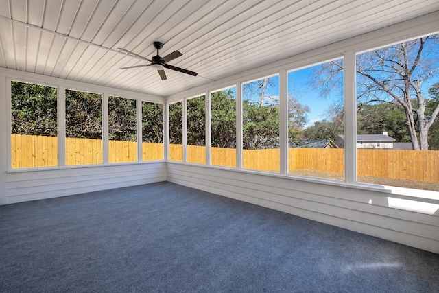 unfurnished sunroom with a ceiling fan, wood ceiling, and plenty of natural light