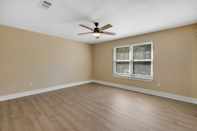 empty room with baseboards, ceiling fan, visible vents, and light wood-style floors