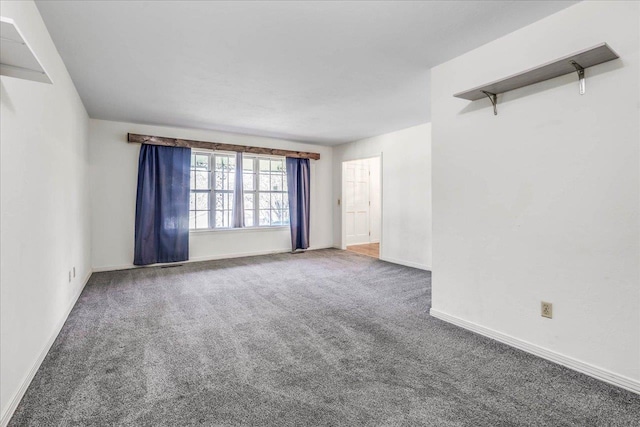 carpeted spare room featuring baseboards