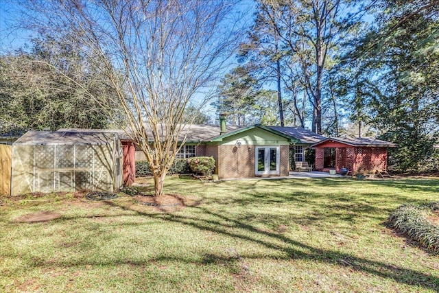 view of yard with an outbuilding, a patio, and french doors