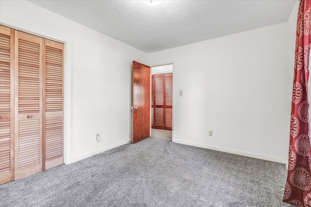 unfurnished bedroom featuring carpet floors, a closet, and baseboards