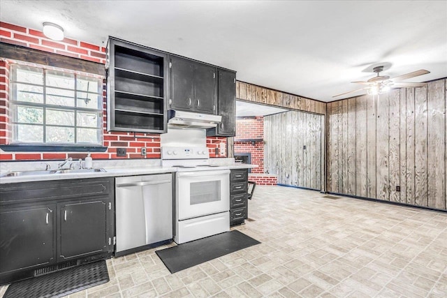 kitchen with electric range, dishwasher, dark cabinetry, under cabinet range hood, and a sink