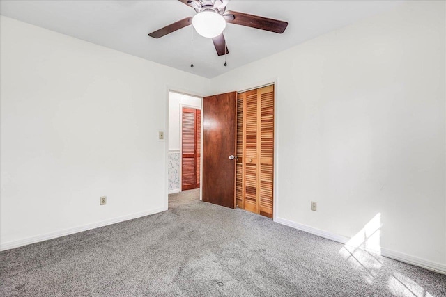 carpeted spare room with ceiling fan and baseboards