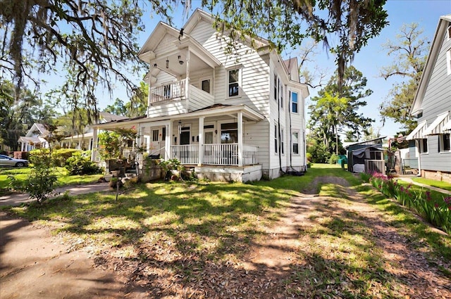 230 E Washington St, Quincy, FL 32351 - view of front facade featuring a porch, a balcony, central AC unit, and a front yard