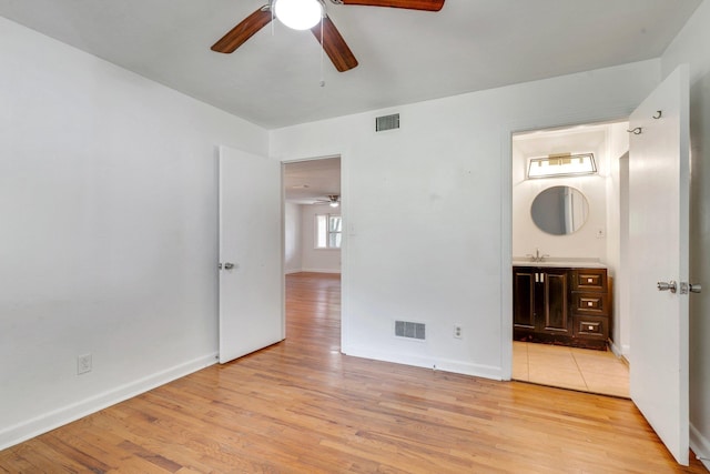 unfurnished bedroom with sink, light hardwood / wood-style flooring, ensuite bath, and ceiling fan