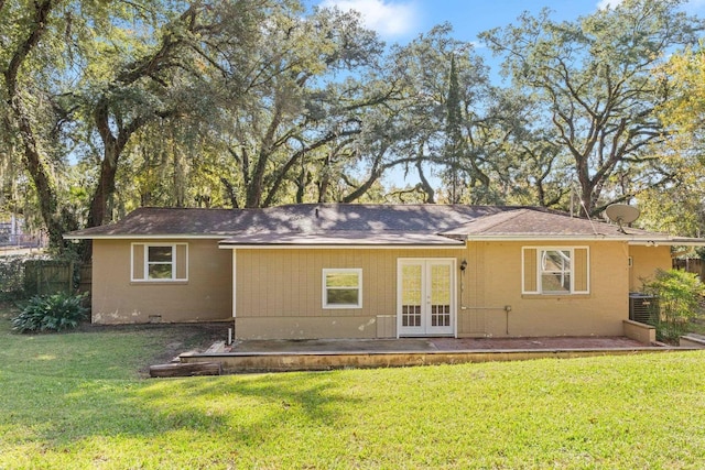 back of property with a yard, french doors, a patio, and central AC unit