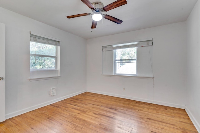 spare room with a wealth of natural light, ceiling fan, and light wood-type flooring