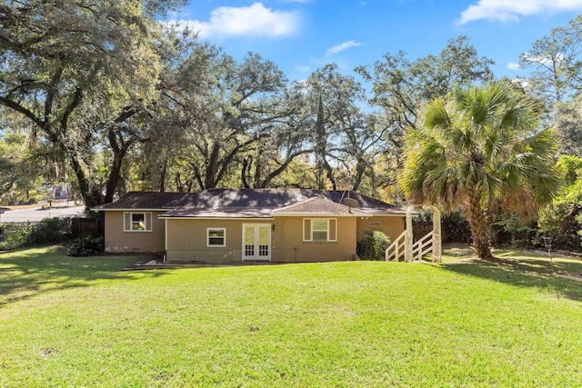 back of house with french doors and a yard