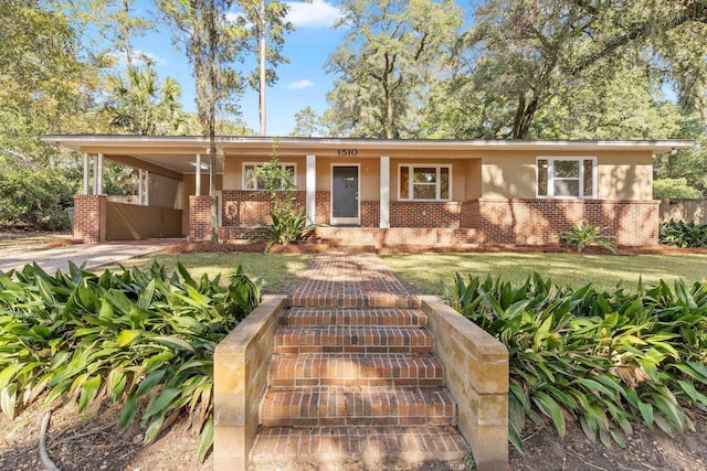 view of front of property with a front lawn, a porch, and a carport