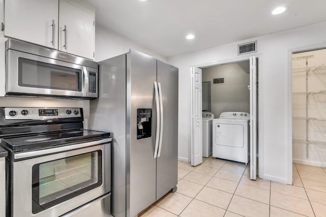 kitchen featuring white cabinets, light tile patterned flooring, independent washer and dryer, and appliances with stainless steel finishes