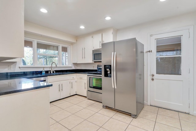 kitchen featuring light tile patterned flooring, white cabinetry, sink, and appliances with stainless steel finishes